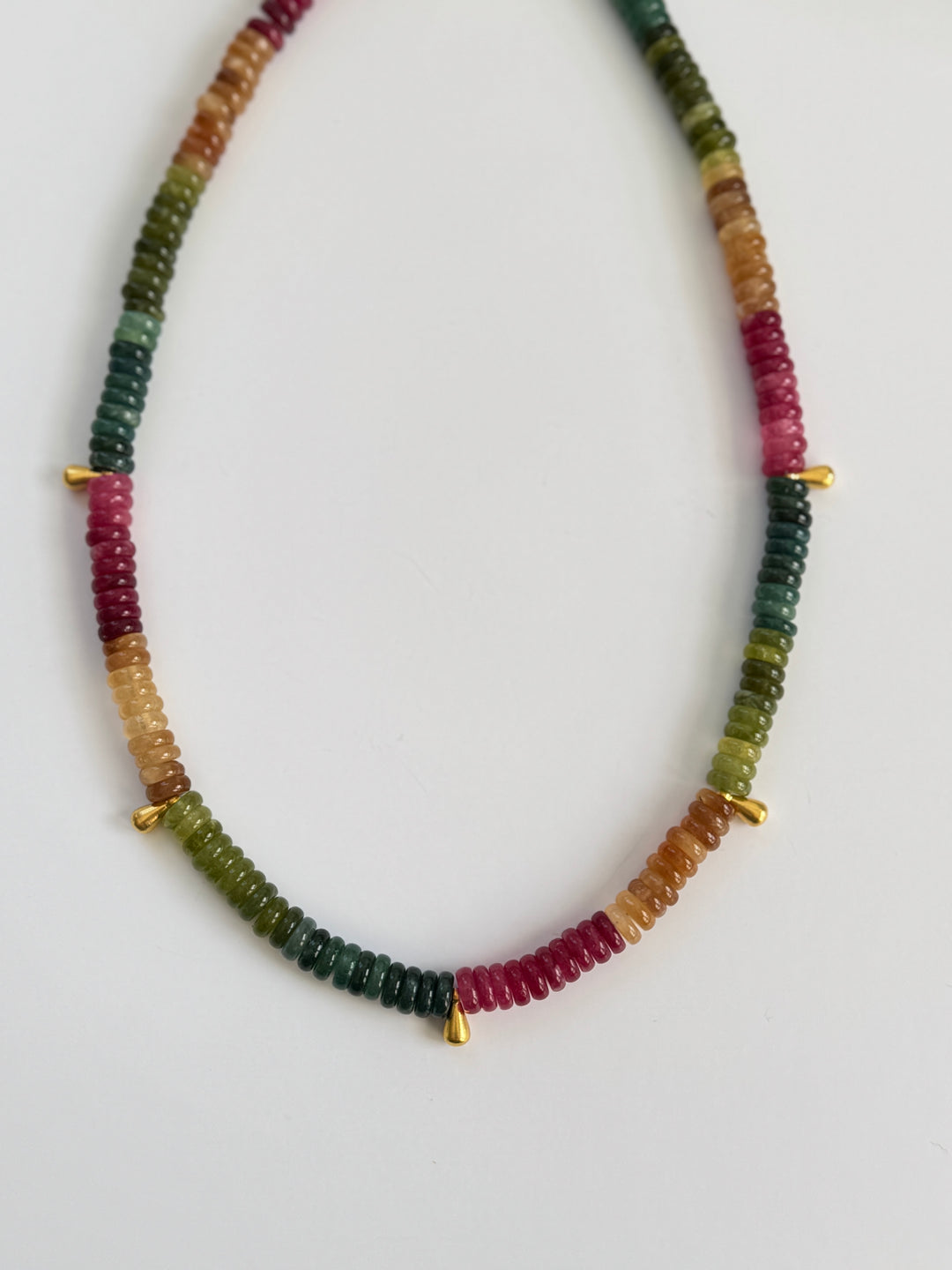 Necklace with multicolored jade rondelle beads on a white background