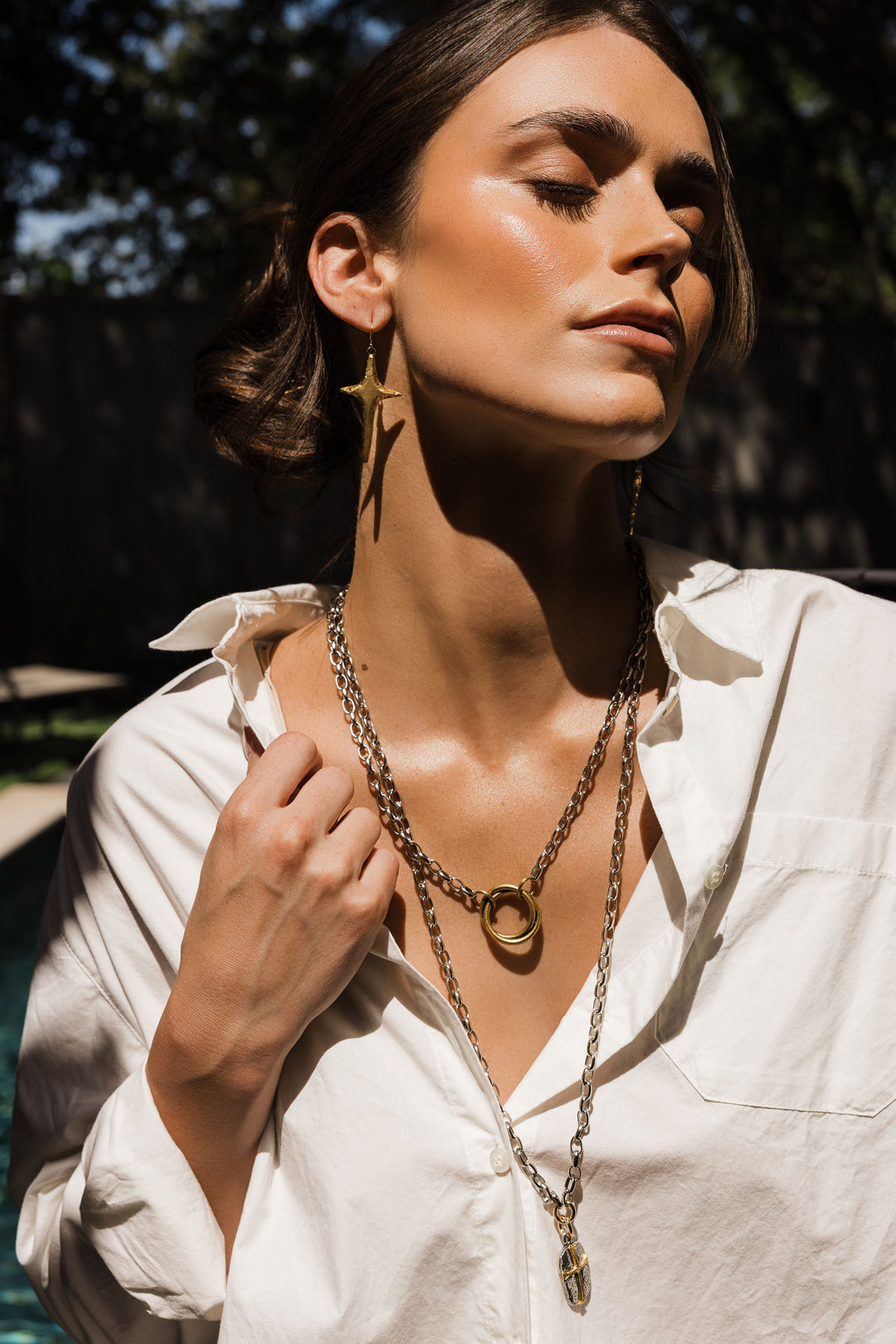 Silver link chain with double ring pendant in gold.

